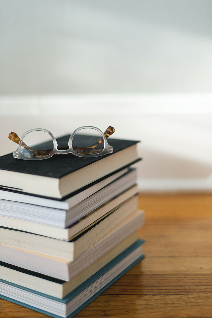 a stack of books with a pair of glasses on top