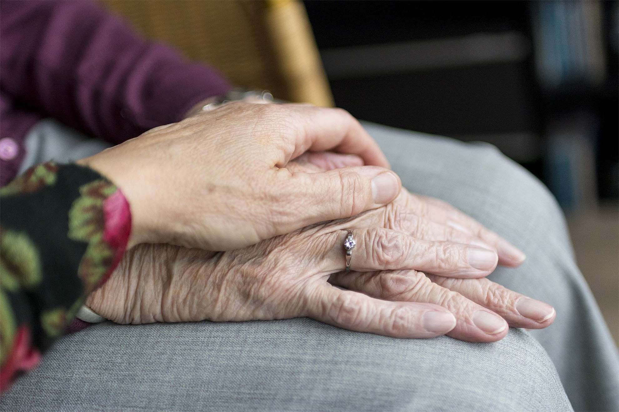 residents with hands on top of each other comforting