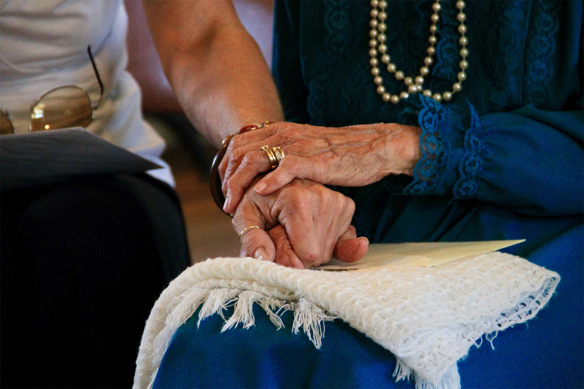 resident and carer holding hands