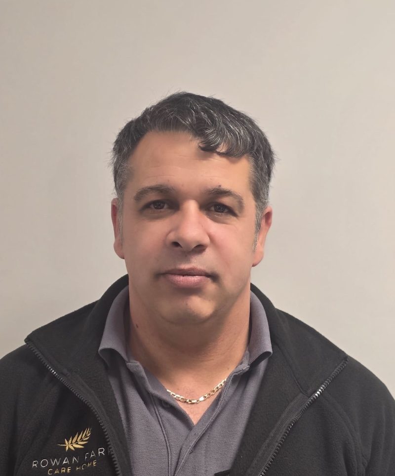 man with black hair and a branded fleece on having a headshot taken for the Rowan Park team page