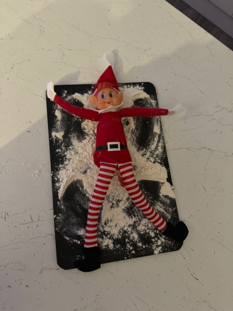 elf on the shelf doing snow angels in the flour