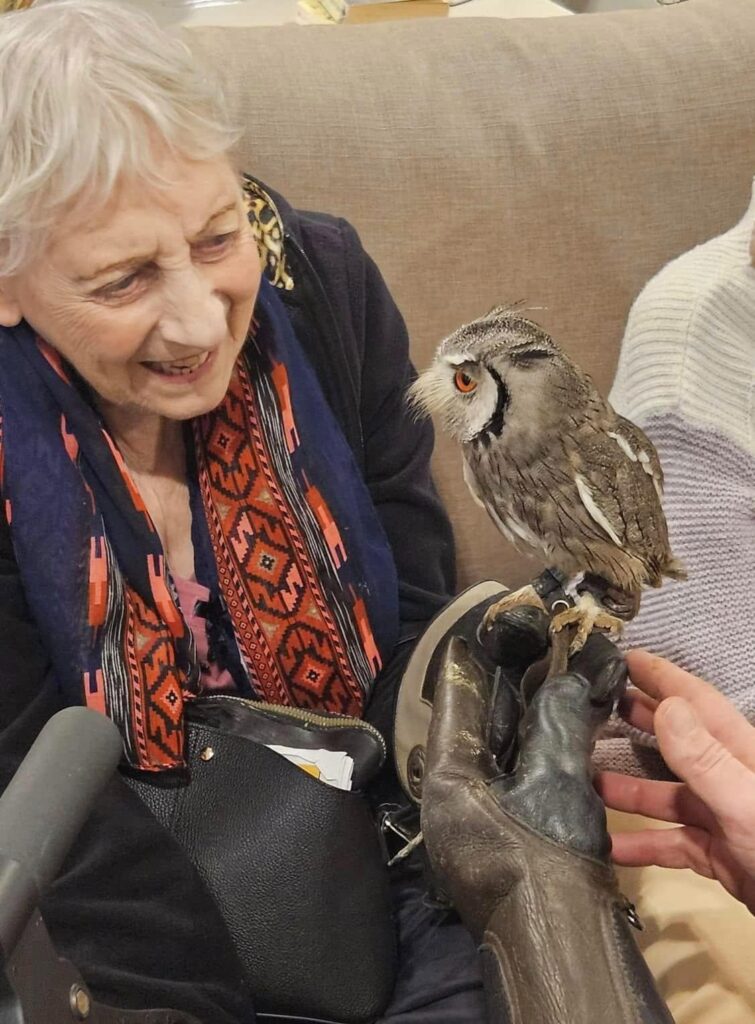 resident smiling whilst holding owl