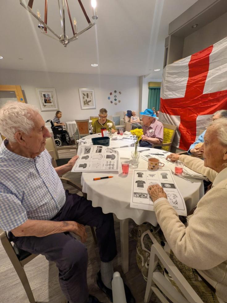 residents sat around a table with world cup bingo cards