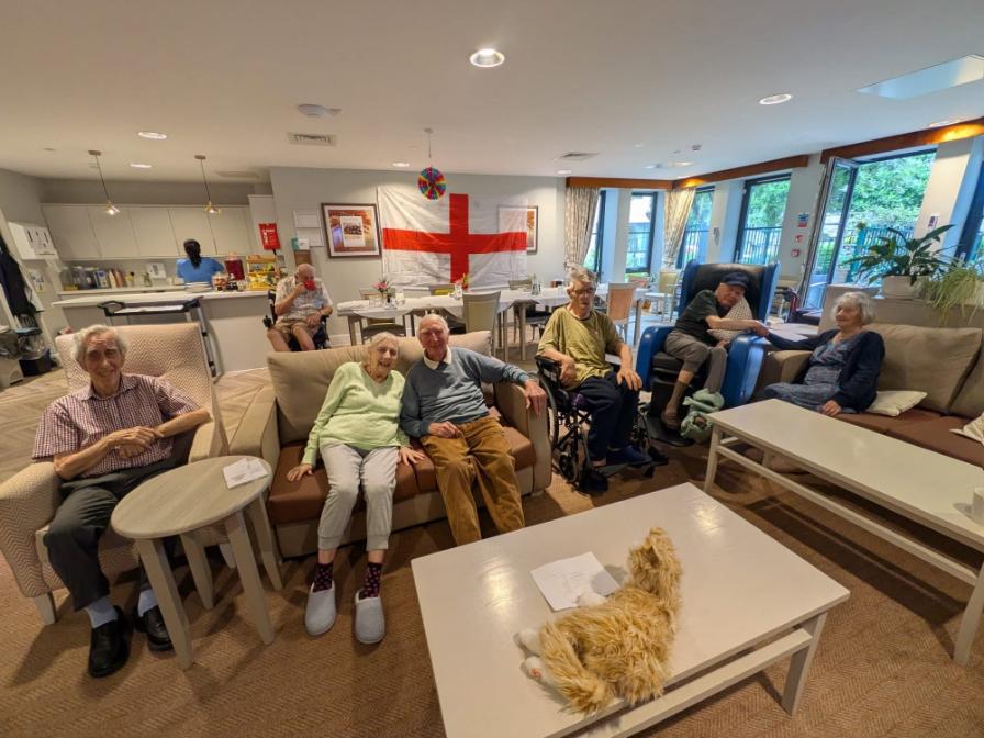 residents sat in a lounge with an england flag behind them