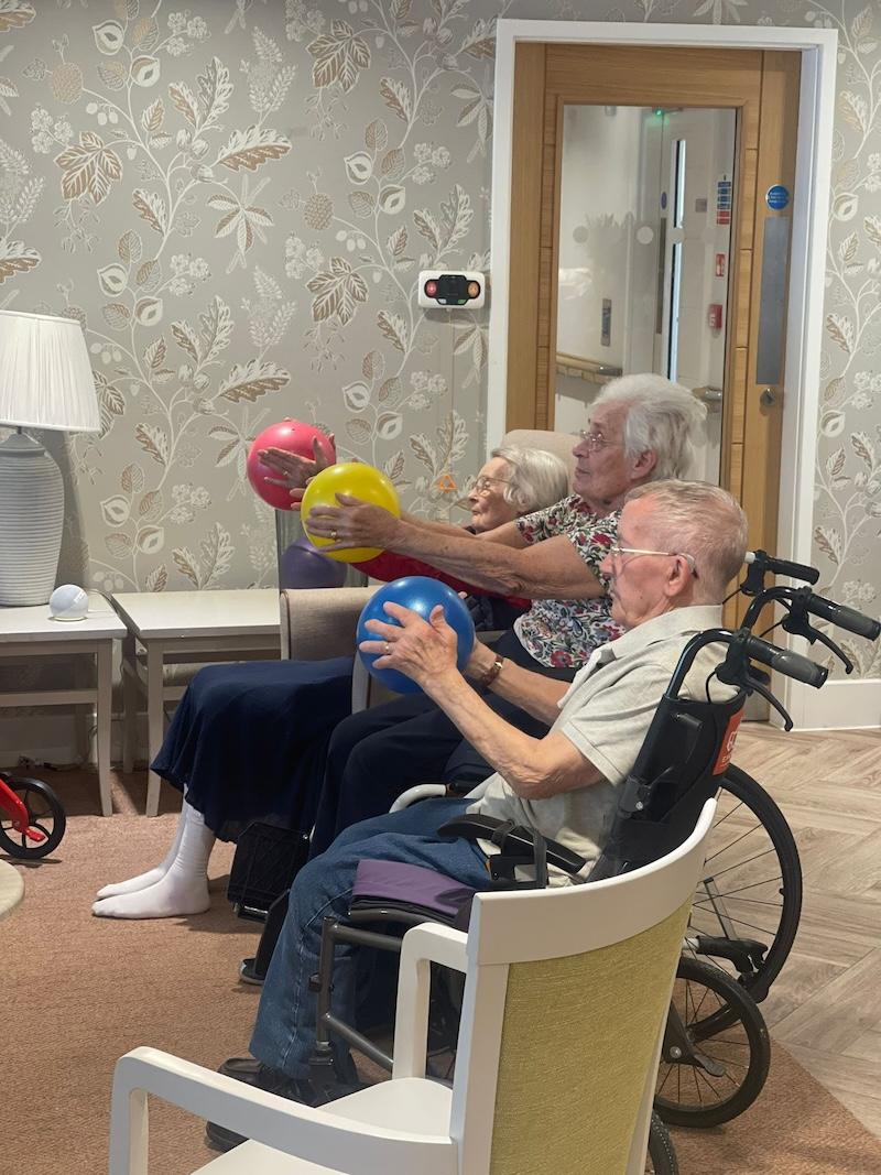 residents sat in wheelchair holding balloons