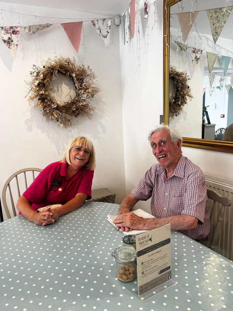 resident sat with a carer smiling